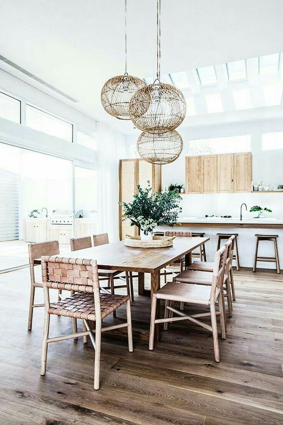 a boho beach dining space with wicker furniture and pendants looks very fresh and modern