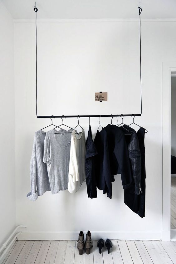 a minimalist hanging rack on black rope and a pipe for a minimal space