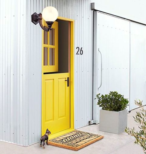 a creative entrance with a bright yellow Dutch door and a fun pritned rug