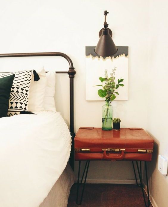 a vintage suitcase placed on trendy hairpin legs gives a cool boho chic nightstand