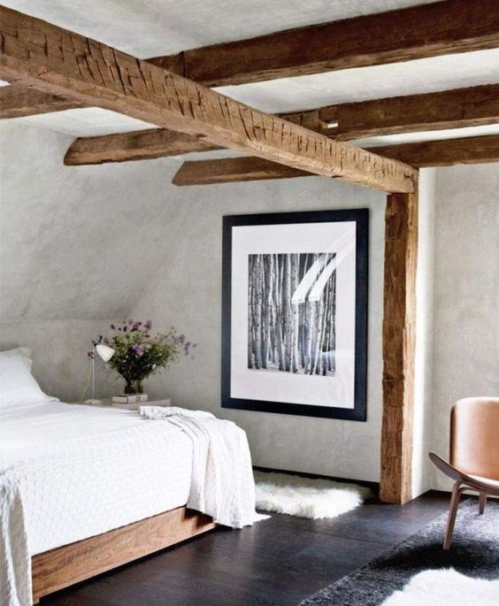 off-white plaster walls and a ceiling plus wooden beams bring a vintage feel and modern furniture for an edgy touch