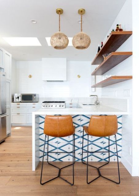 a modern coastal kitchen with wicker pendants and blue mosaic tiles on the kitchen island