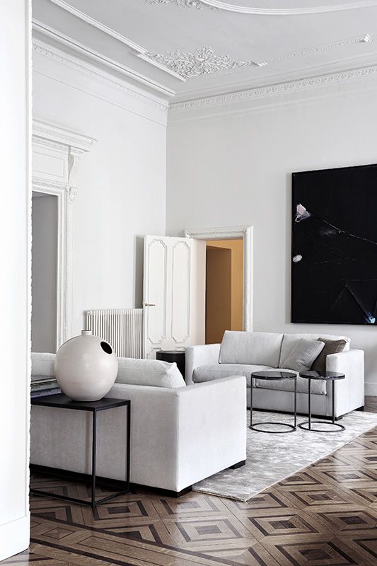 a refined monochromatic living room with two white sofas and some black touches