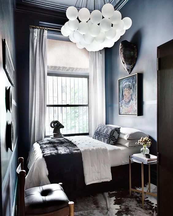 a large and bold chandelier makes a statement in this moody lux guest bedroom