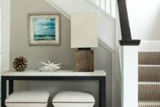 14 a minimalist beach console with starfish, a wooden ball and a bold sea-inspired artwork over the table