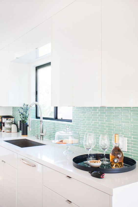 a minimalist kitchen with an aqua tile backsplash is a fresh take on a coastal kitchen