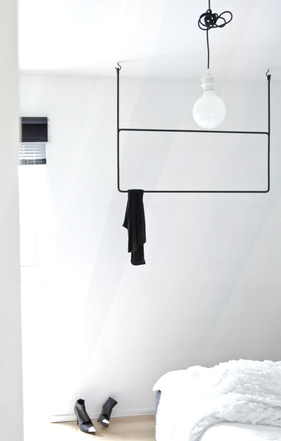 a minimalist black rack with two shelves attached to the ceiling for a Scandinavian space