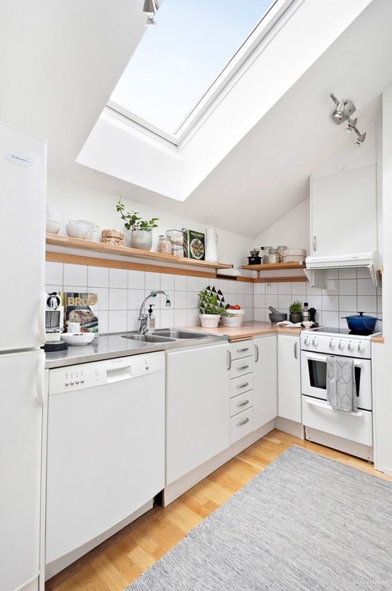 a small contemporary white kitchen with a skylight doesn't seme too smal thanks to light and white