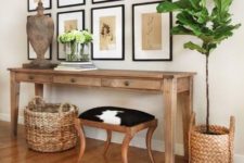 15 a summer console with baskets around, a wooden sculpture, greenery and vintage botanical artworks