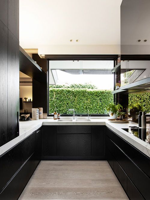 a black and white space with a large window that lets you enjoy the garden views