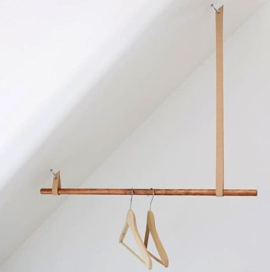 a creative idea for an attic space of a wooden stick and some leather loops looks chic
