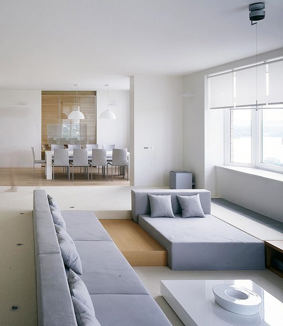 a minimalist sunken living room with geometric furniture and a view