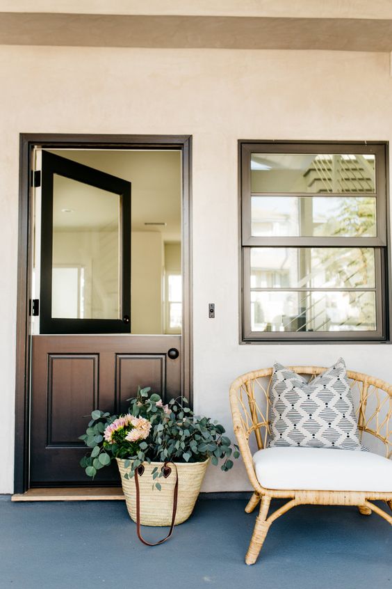a stylish contemporary meets rustic entrance with a black Dutch door with a solid glass insert