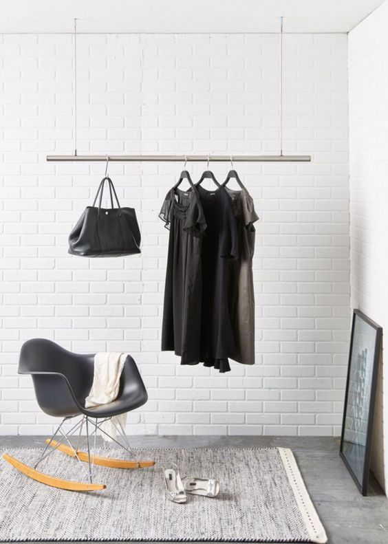 a ceiling rack of a metal pipe and ropes for a modern monochrome space