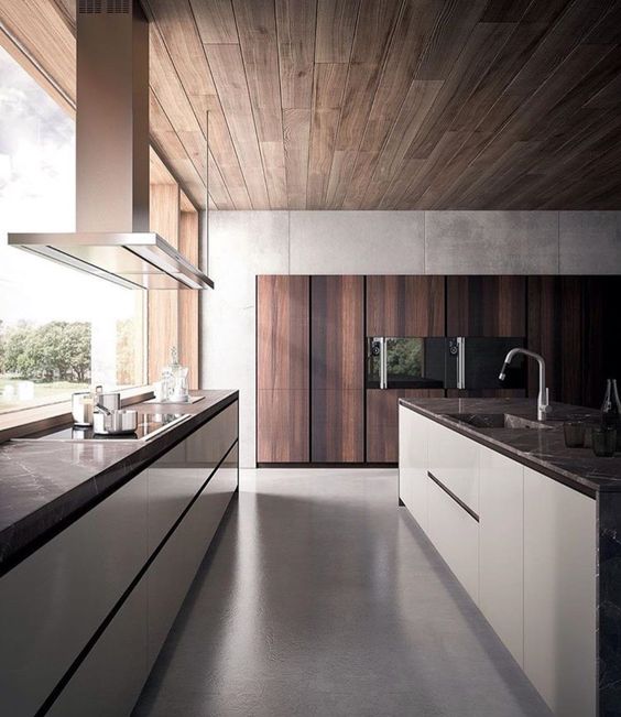 A contemporary kitchen in white and rich colored wood with a window as a backsplash