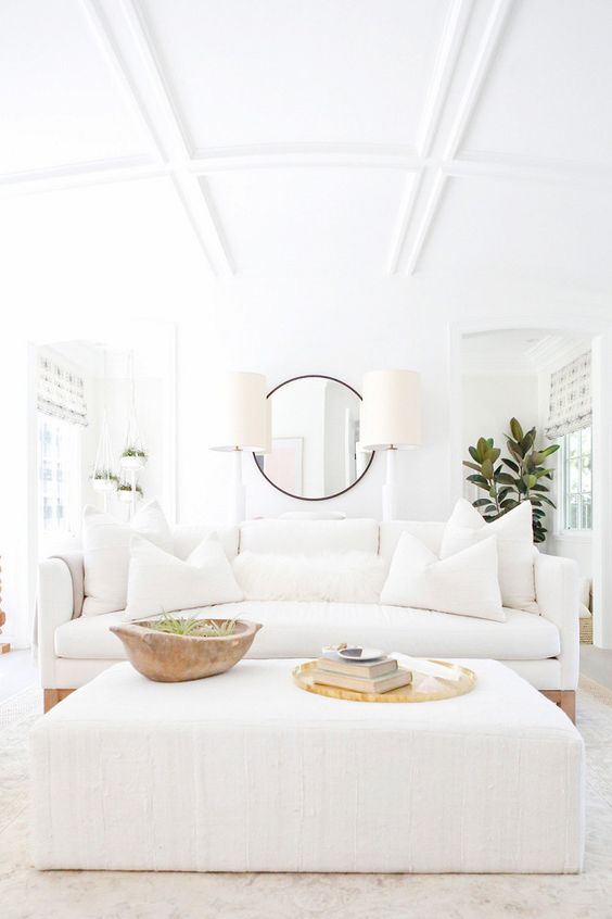 a modern white sofa with matching pillows on wooden legs looks fresh and non-boring