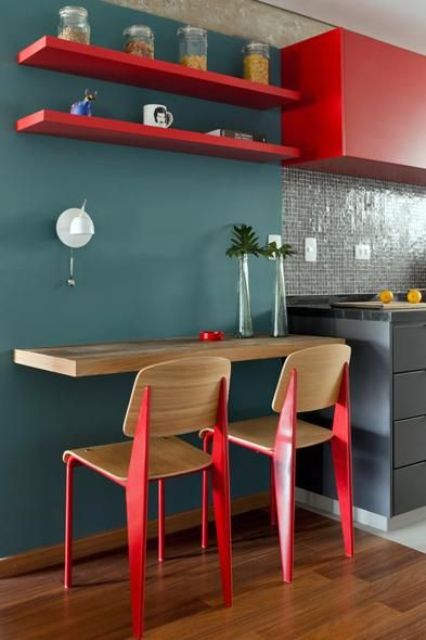 a small colorful breakfast space with a wall-mounted tabletop and shelves over the space