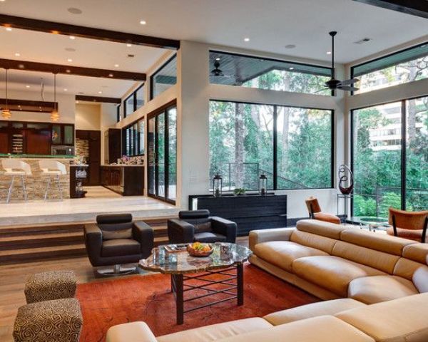 A mid century modern sunken living room with elegant furniture and much light coming through windows