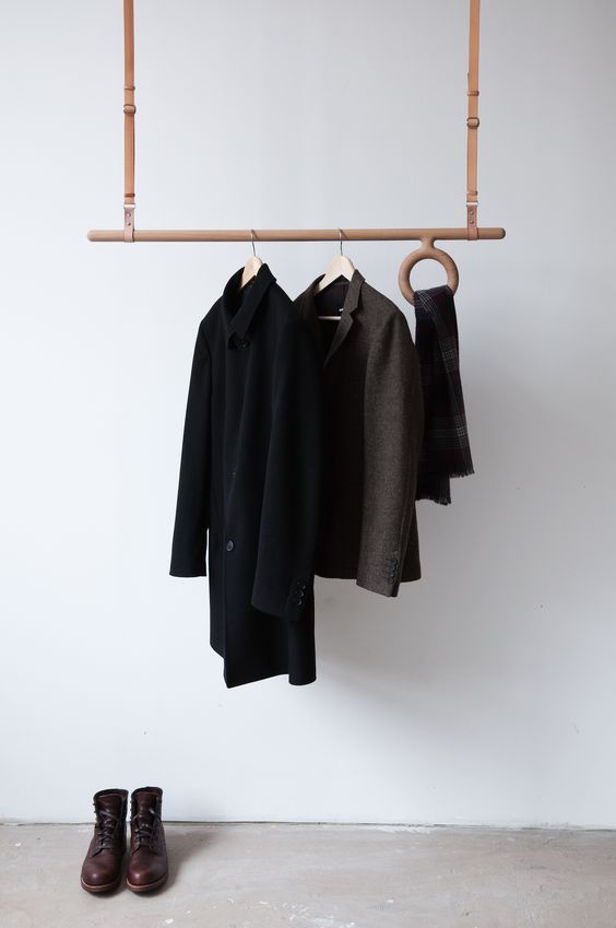 a creative wood and leather rack hanging from the ceiling with a ring for scarves