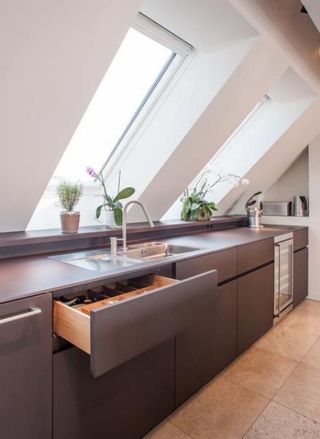 a minimalist grey kitchen with a couple of skylights plus additional light