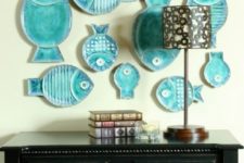 19 a whimsical gallery wall made of turquoise fish-shaped decorative plates is a cute idea