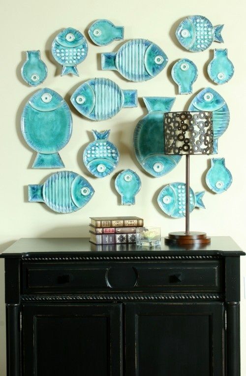 A whimsical gallery wall made of turquoise fish shaped decorative plates is a cute idea