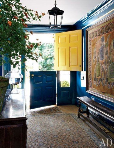 a bold entryway with a bright blue and yellow Dutch door that makes a colorful statement