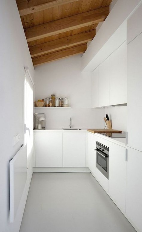 a minimalist white kitchen with a wooden ceiling and a window to make the space ethereal