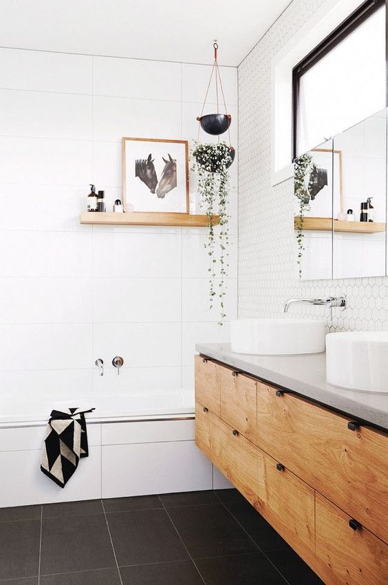 a white bathroom space is spruced up with a black floor and a wooden shelf and vanity