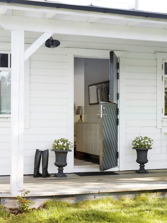 A black striped Dutch door is a bold contrasting touch for a white house