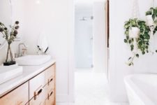 21 a clean white space with a large light-colored wood vanity and some potted greenery