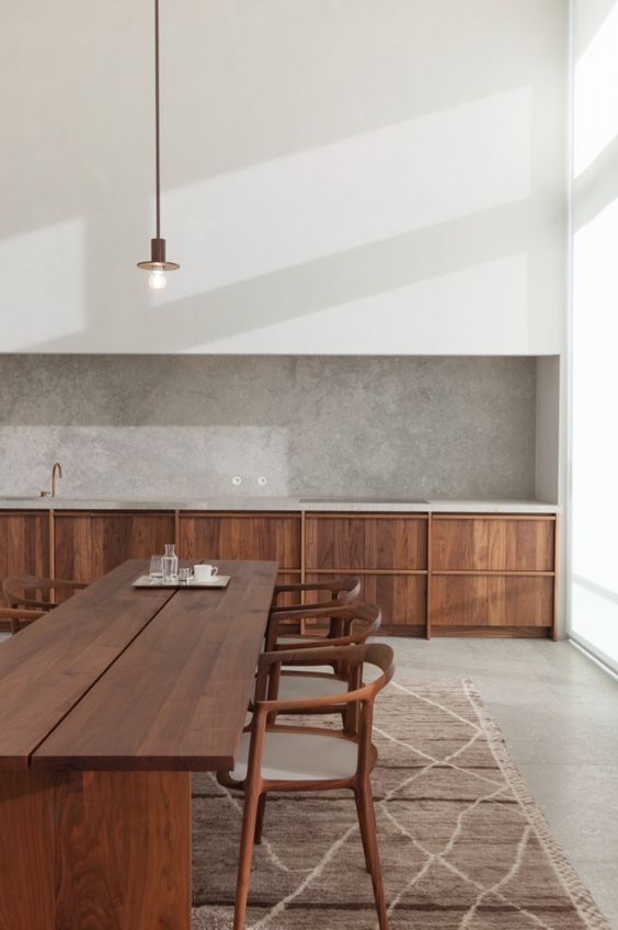 a minimalist kitchen with a grey plaster backsplash that adds color and texture to the space