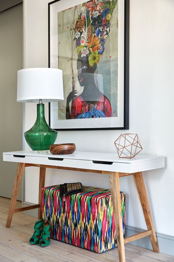 a super colorful artwork, a bright upholstered ottoman and a green lamp for summer