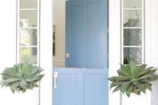 22 a clean modern beach house entrance with large succulents and a blue Dutch door