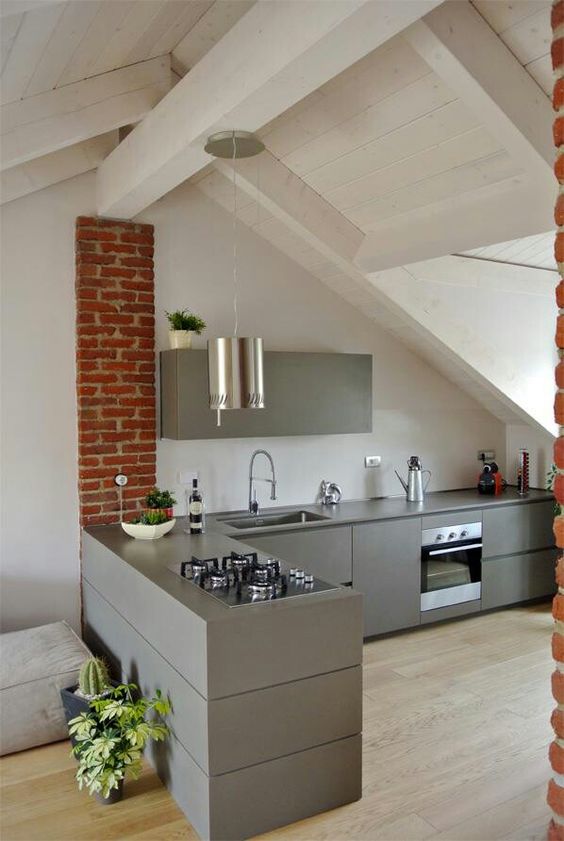 a minimalist kitchen with skylights and brick touches plus a pendant lamp to highlight the ceiling height