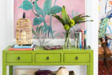 22 a super colorful console with a birdcage candle holder, greenery, a bold artwork and a basket with colorful textiles