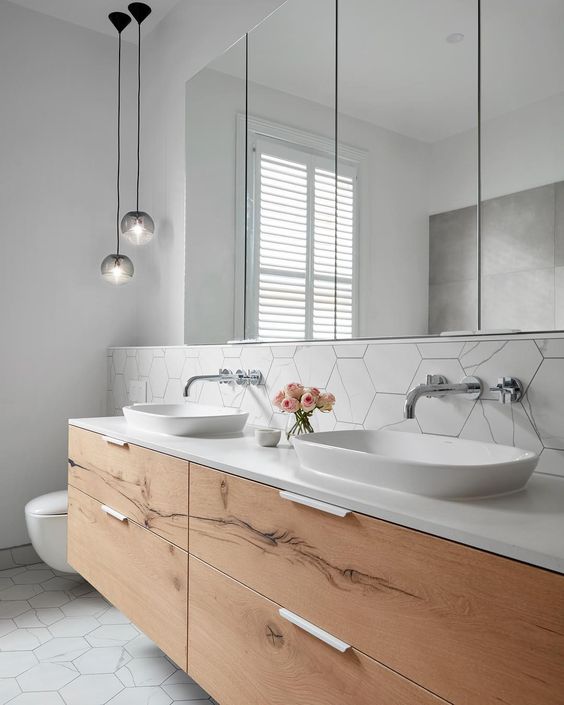 a white bathroom with a minimalist wooden vanity plus white sinks