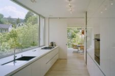 23 a serene white minimalist ktichen with a panoramic window to enjoy the views