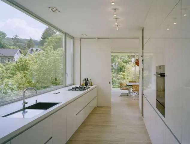 a serene white minimalist ktichen with a panoramic window to enjoy the views