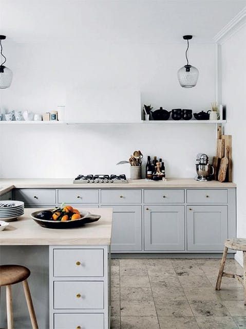a white plaster wall and backsplash plus light grey cabinets for a serene kitchen look