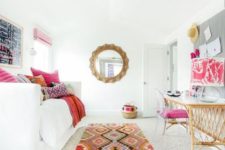 23 an adorably colorful guest bedroom with a convertible sofa and a wicker desk plus a pink chair