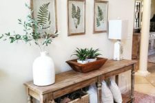 24 a wooden console, botanical artworks, potted greenery and a basket for storage for summer