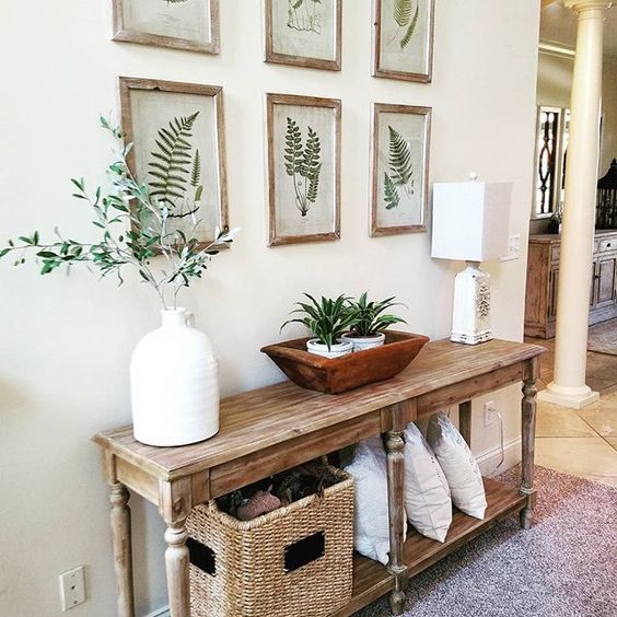 a wooden console, botanical artworks, potted greenery and a basket for storage for summer