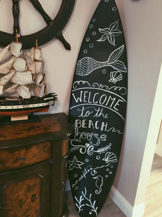 DIY chalk surfboard is a unique and modern artwork idea for a beach home