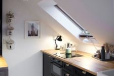 25 a Scandinavian attic kitchen with black cabinets, wooden countertops and skylights