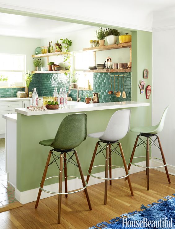 a raised up breakfast bar is attached to a kitchen island and tall stools are comfy for sitting