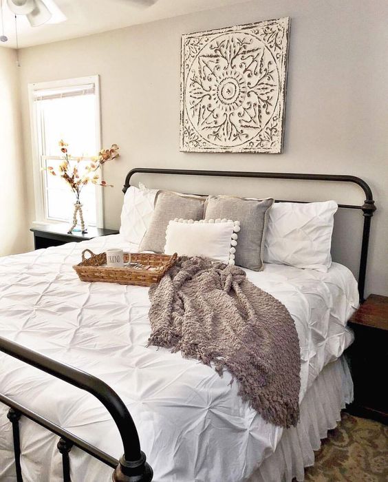 a cozy farmhouse style guest bedroom with an artwork and some baskets