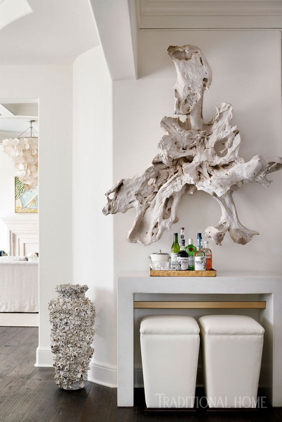 a large whitewashed piece of driftwood is a unique wall art idea for a coastal home