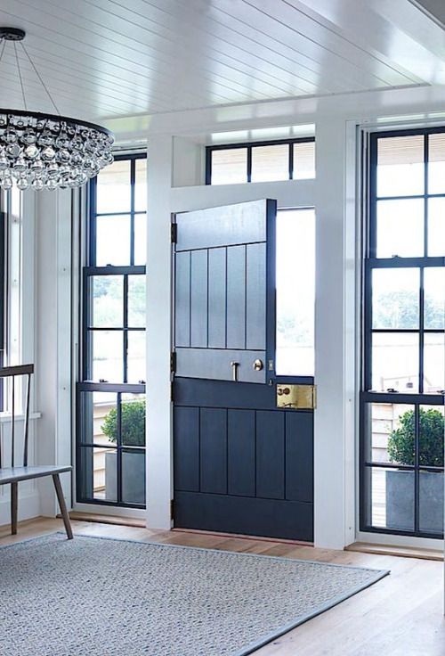 a stylish contemporary entryway with a navy Dutch door and windows on both sides