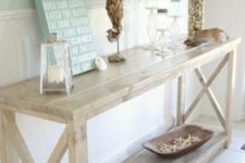 26 a whitewashed console table, candles in glass candle holders, starfish, a sea horse of driftwood and a shell clad vase